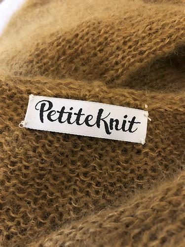 PetiteKnit tekstillabel med teksten "PetiteKnit", til at sy i nakken af sin striktrøje